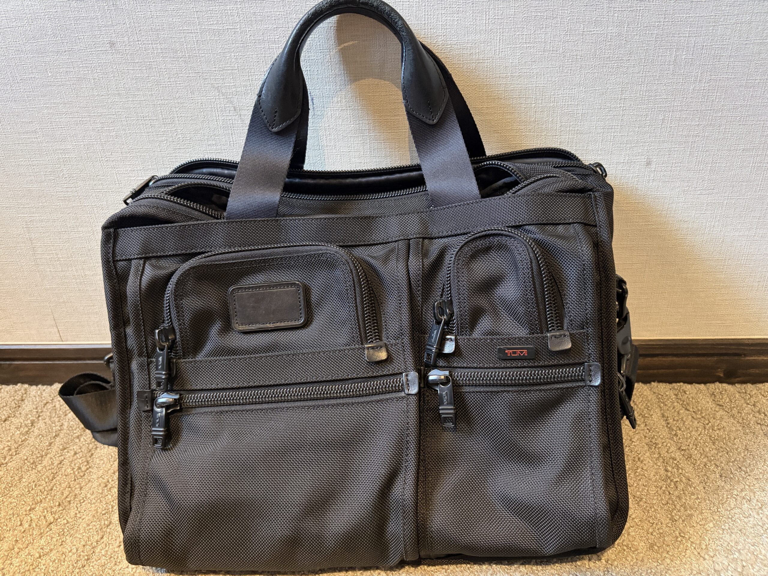 TUMI アルファ ビジネスケースの前面。バリスティックナイロンとTUMIロゴ、デュアルハンドル